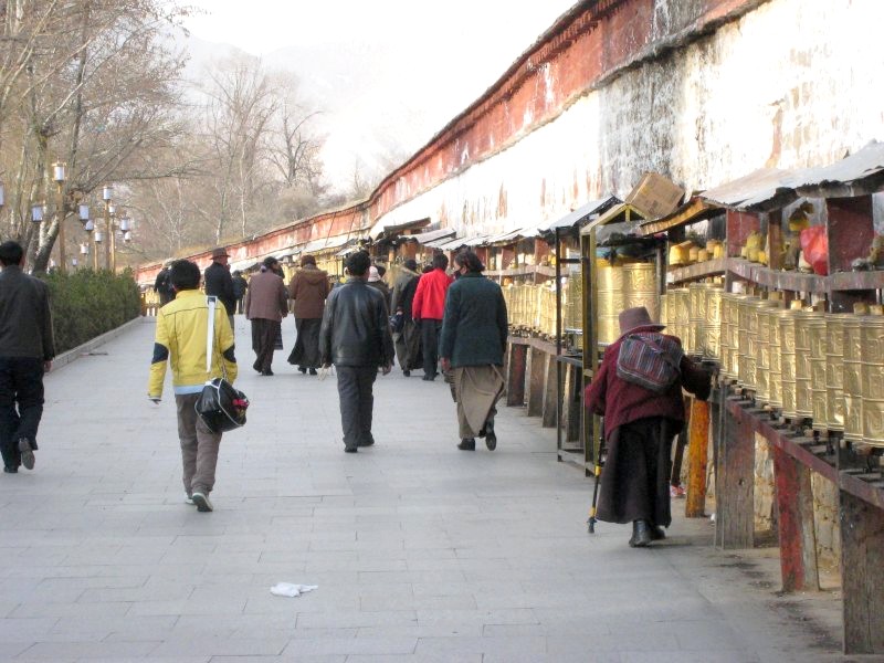 wandern in tibet 024 pilger an den gebetstrommeln am potala palast.jpg